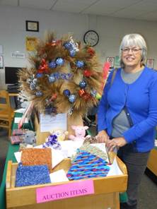 A friend of the library showing off a display of silent auction items