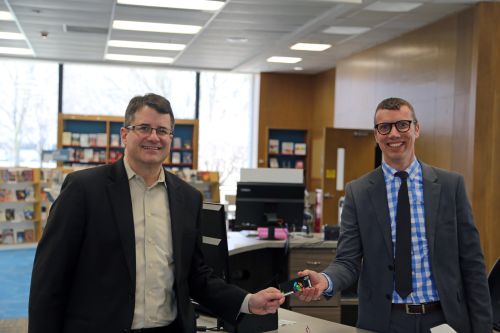 Scott Duimstra and Bradley Funkhouser exchange a CADL Card in the Downtown Lansing Branch of CADL