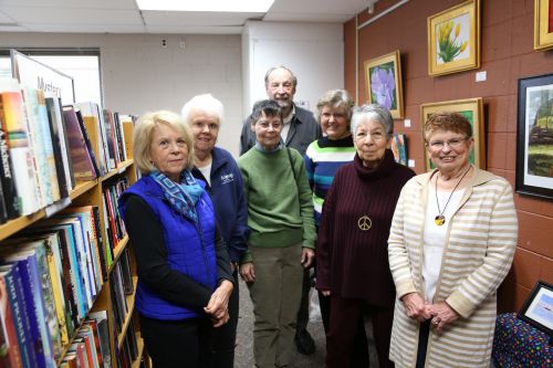 7 members of the Haslett friends pose in the Bookend used book store
